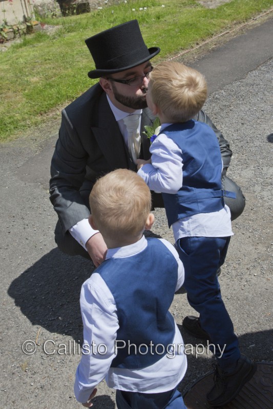 groom in top hat greets boys