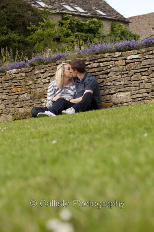 couple beside cotswold stone wall