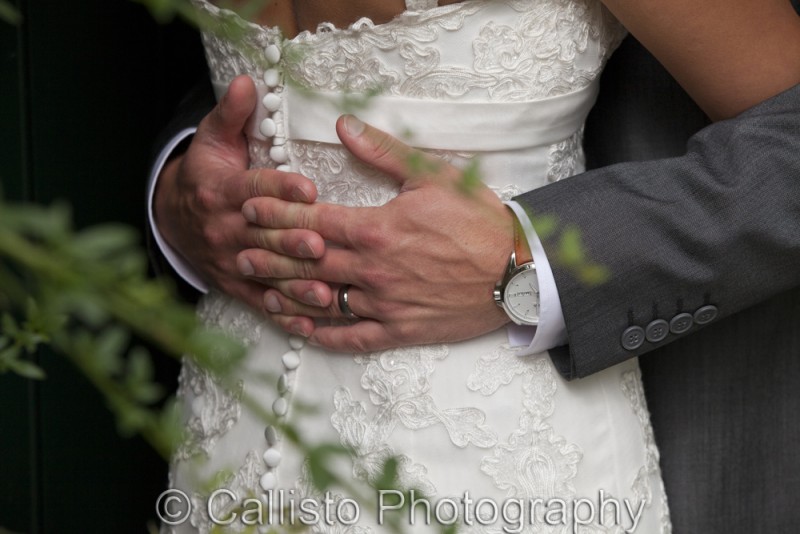 grooms hands on wedding dress